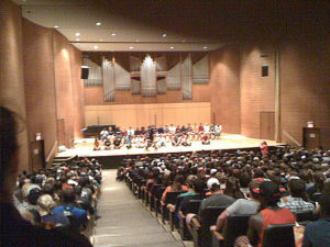 college hypnotist cj johnson on stage in a full auditorium